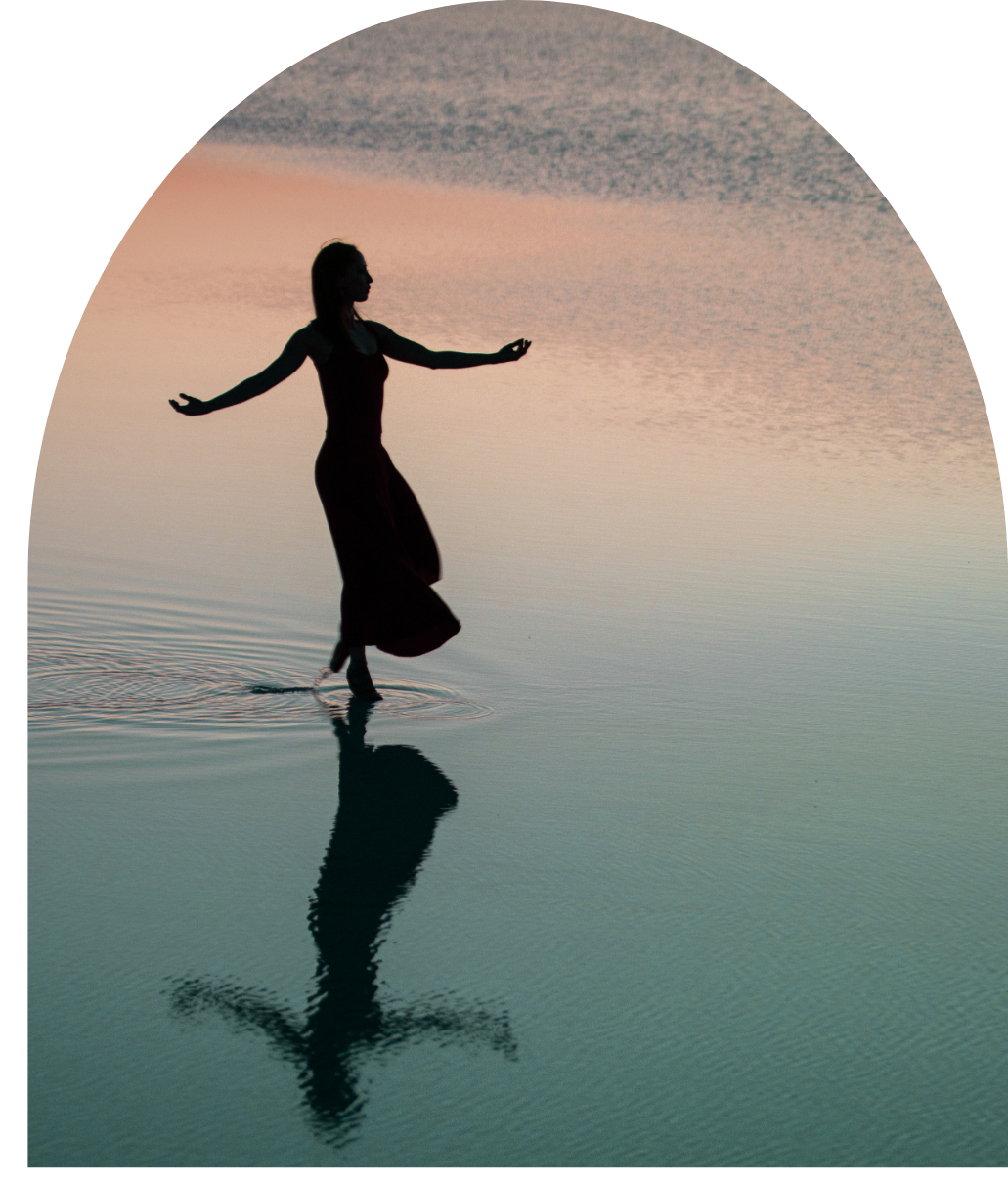Eine Frau tanzt im flachen Meer